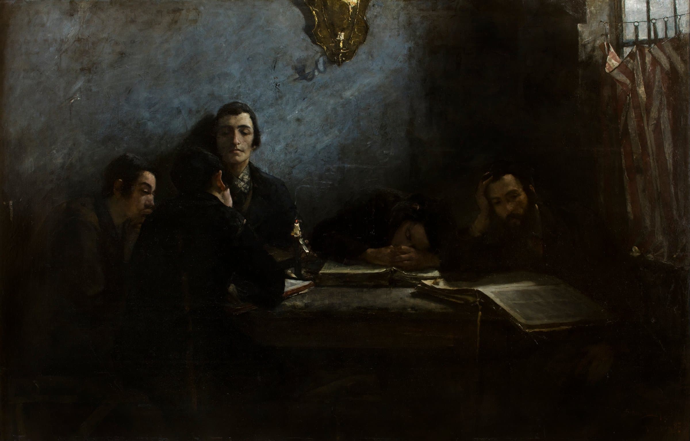 Five men sit around a dark table with open books in a dim room lit by a small candle, one asleep with his head on his arms and another resting his head on his hand beside a barred window.