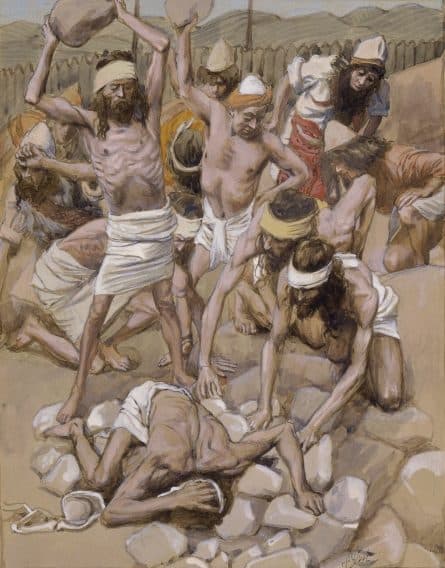 A man lies face down on a heap of stones while a crowd of bearded men in head cloths and loincloths raise stones over him, with a wooden fence and hills behind them.