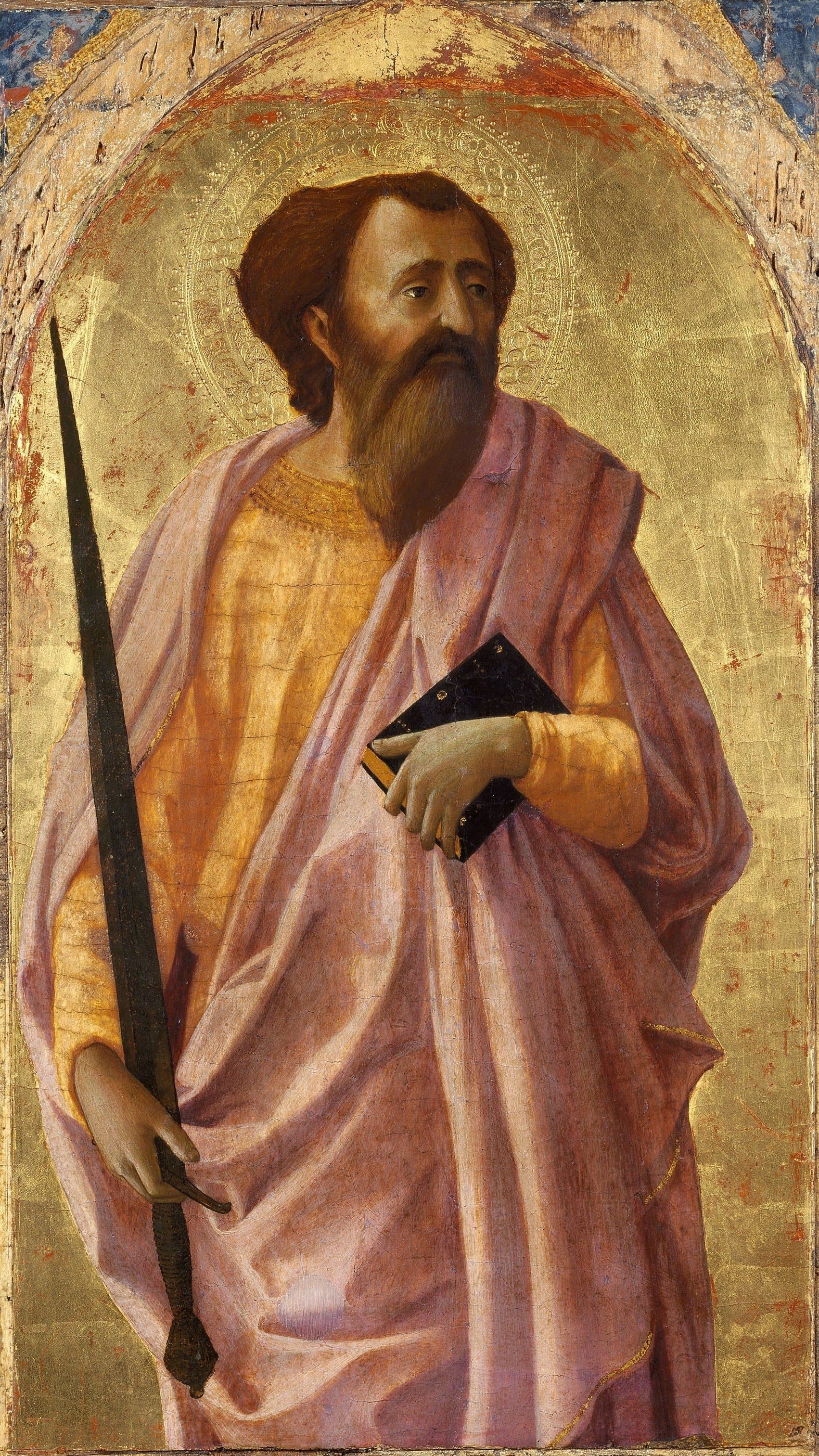 A painted panel of the apostle Paul standing against a gold ground under a pointed arch, bearded and with a halo, in a pink cloak over a gold robe, holding a long sword point upward in his right hand and a black book against his side in his left.