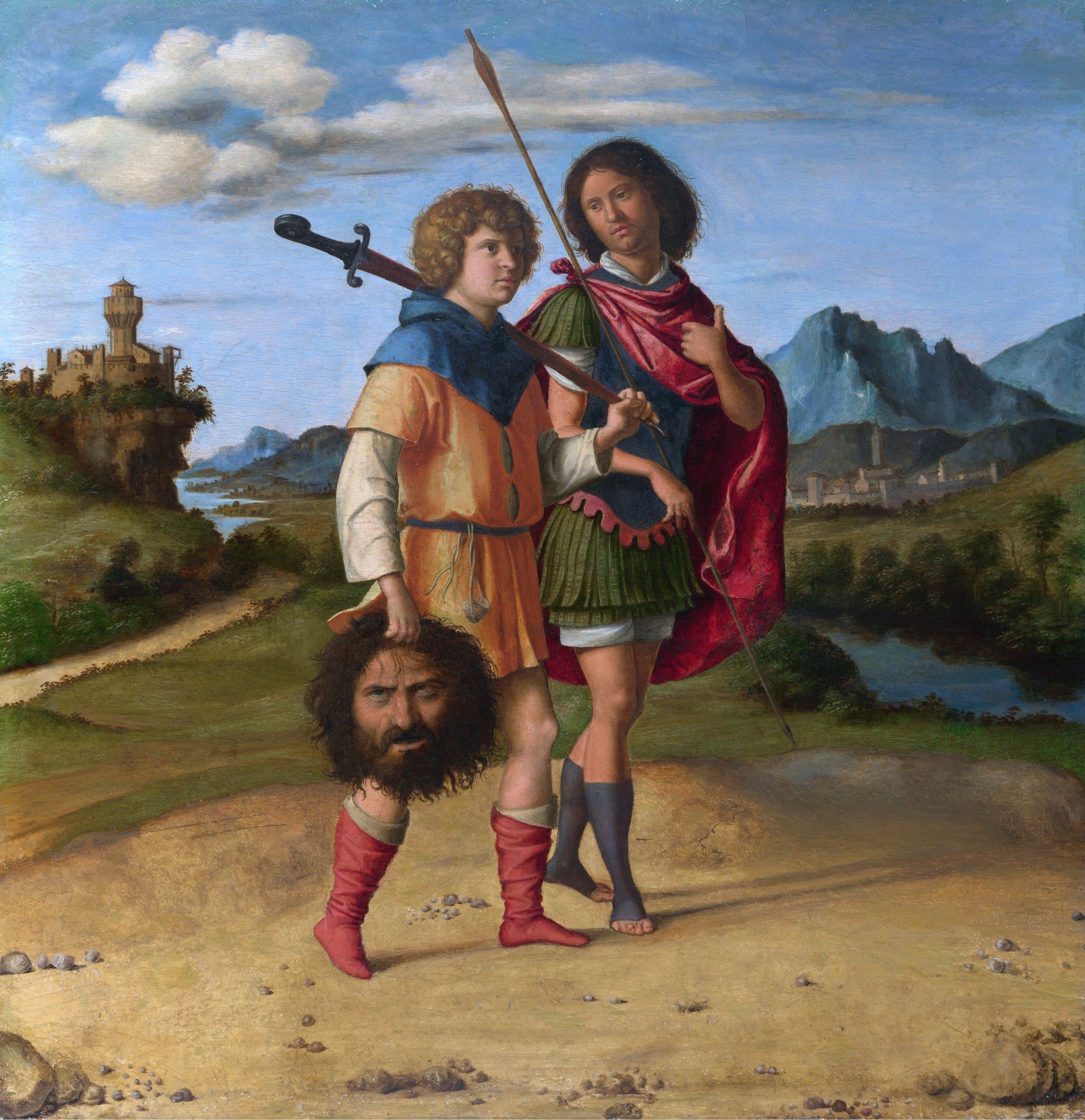 A curly-haired youth in an orange tunic carries a sword on his shoulder and a giant's severed head in his hand, walking beside a young man in a red cloak who holds a spear, in a wide landscape with a hill town behind them.