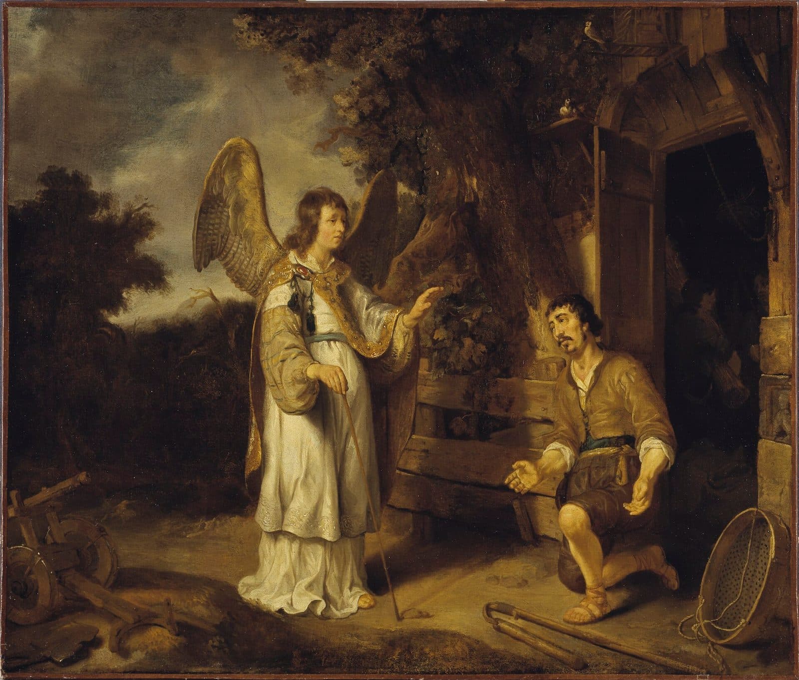 A winged angel in a white robe, holding a staff, speaks to a farmer kneeling under an oak beside a barn door, while a flail and a sieve lie on the ground