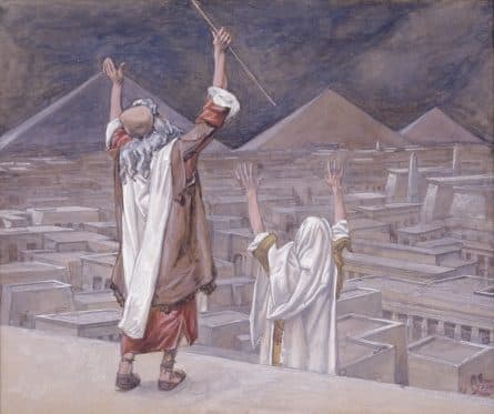 James Tissot's painting of Moses on a rooftop raising his staff over a city of flat roofs, with Aaron lifting his hands beside him and pyramids under a dark sky beyond