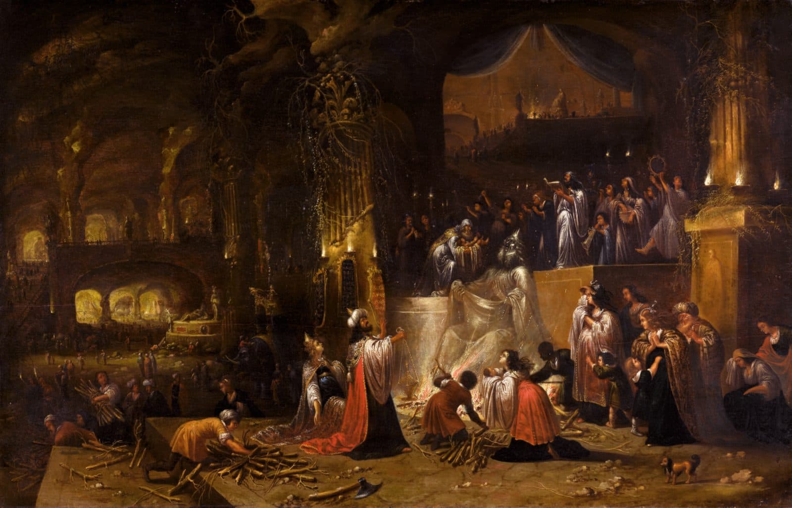 A torchlit cavern of pillars where a crowned king in a red cloak kneels before a fire beneath a seated idol draped in white, a priest lifts a child on the platform above, men carry bundles of wood and women weep at the right.