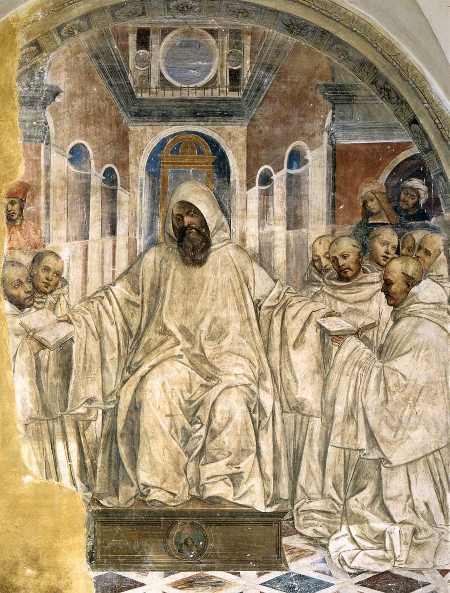 A bearded monk in a white hooded habit sits enthroned under an arch, holding out a book to kneeling monks in white on either side.