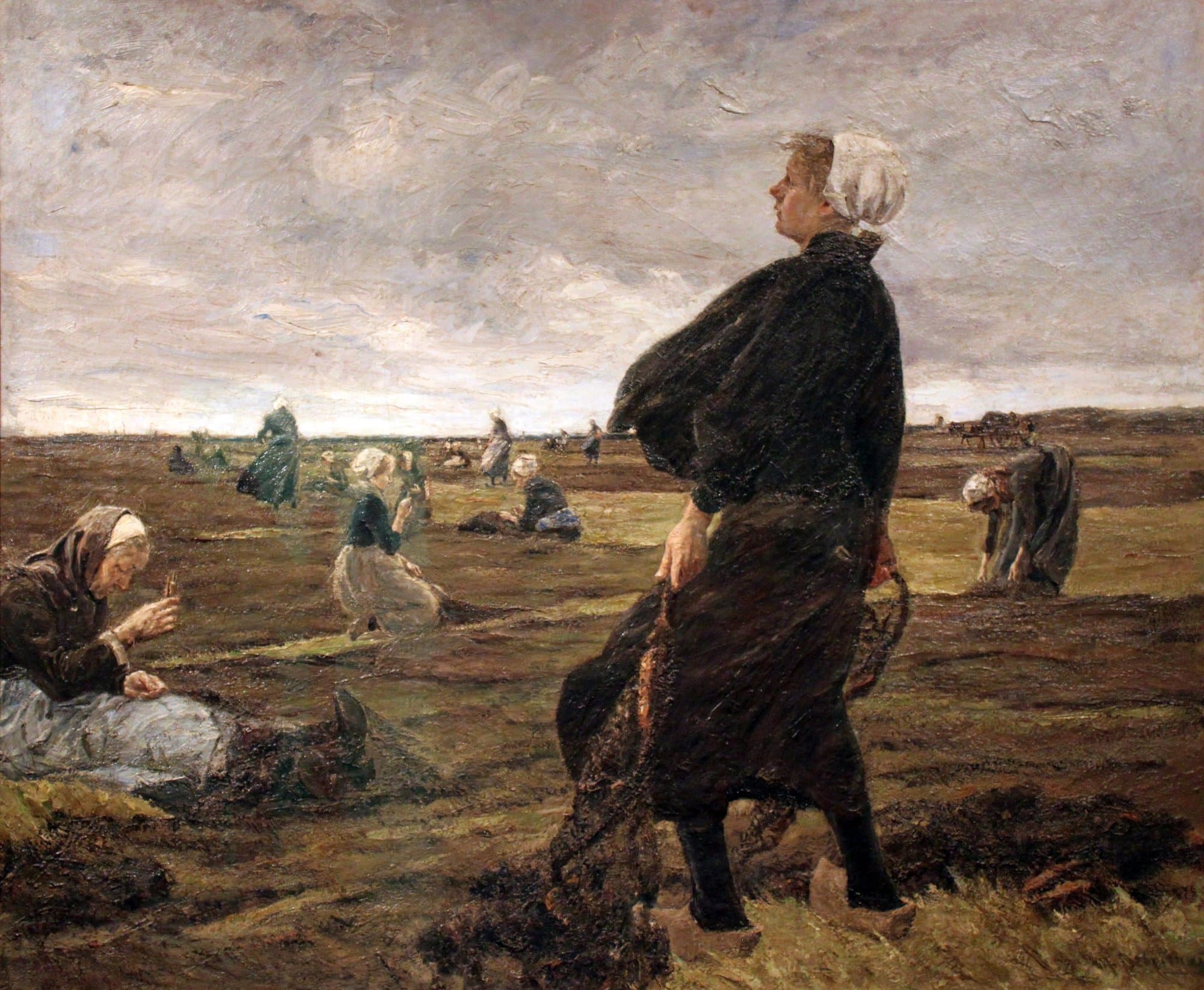 A painting of women mending fishing nets spread across a flat dune meadow under a grey, windy sky: a young woman in a black cape and white cap stands in the foreground with a net in her hands, while others kneel, sit or bend over the nets behind her.