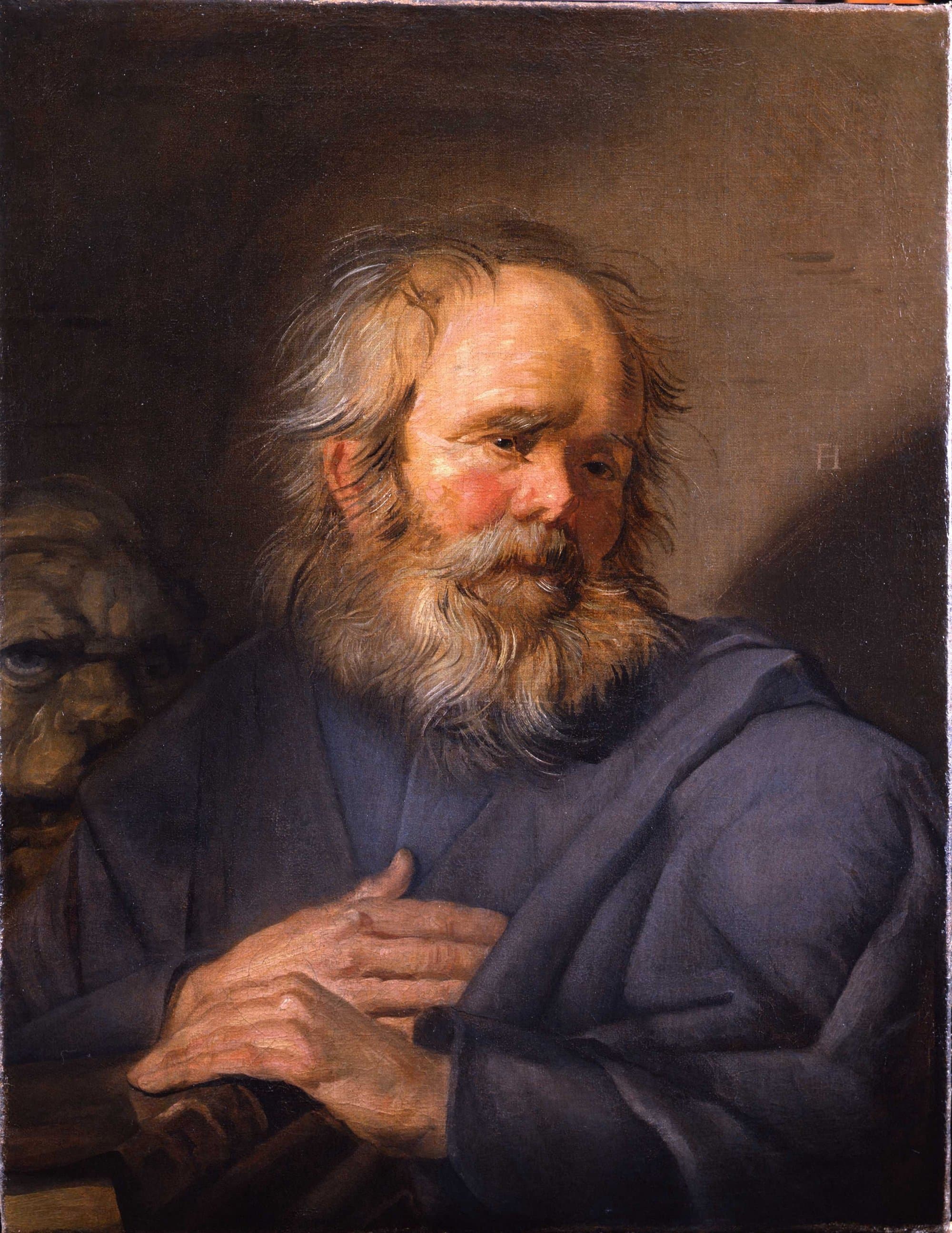 An old man with a full grey beard and flushed cheeks, wrapped in a blue-grey robe, looks down to the right with one hand on his chest and the other resting on a dark book, while the head of a lion shows in the shadow at the left.