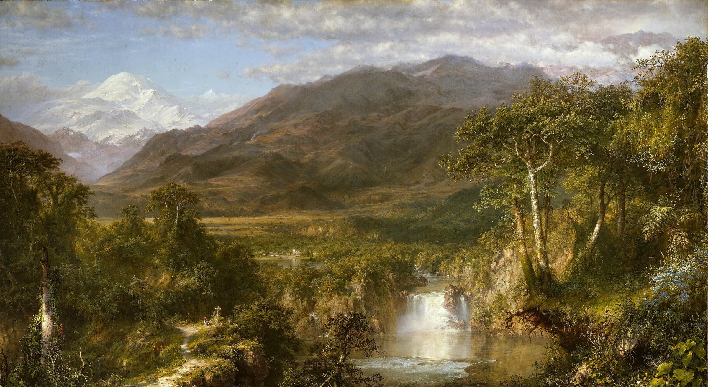 A wide mountain valley under a cloudy sky, with a snow-capped peak on the left, brown ridges across the middle, a village and fields on the plain, and in the foreground a forest, a waterfall falling into a pool, and a path leading to a small wooden cross where two figures stand.