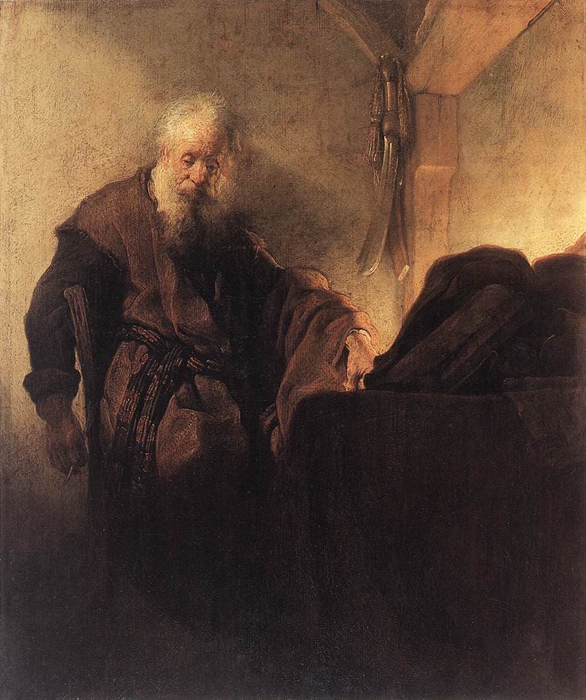 An old man with a white beard and a brown robe sits at a desk in a dim room, his head bowed in thought, one hand resting on a heap of books and papers lit from a window at the right, and a sword hanging on the wall behind him.