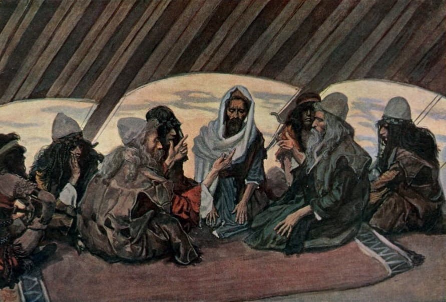 Inside a tent of dark striped cloth, Moses in a white head covering sits in the centre on a rug while an old white-bearded man in a green robe kneels beside him and other bearded men sit around them, one raising a finger as he speaks.