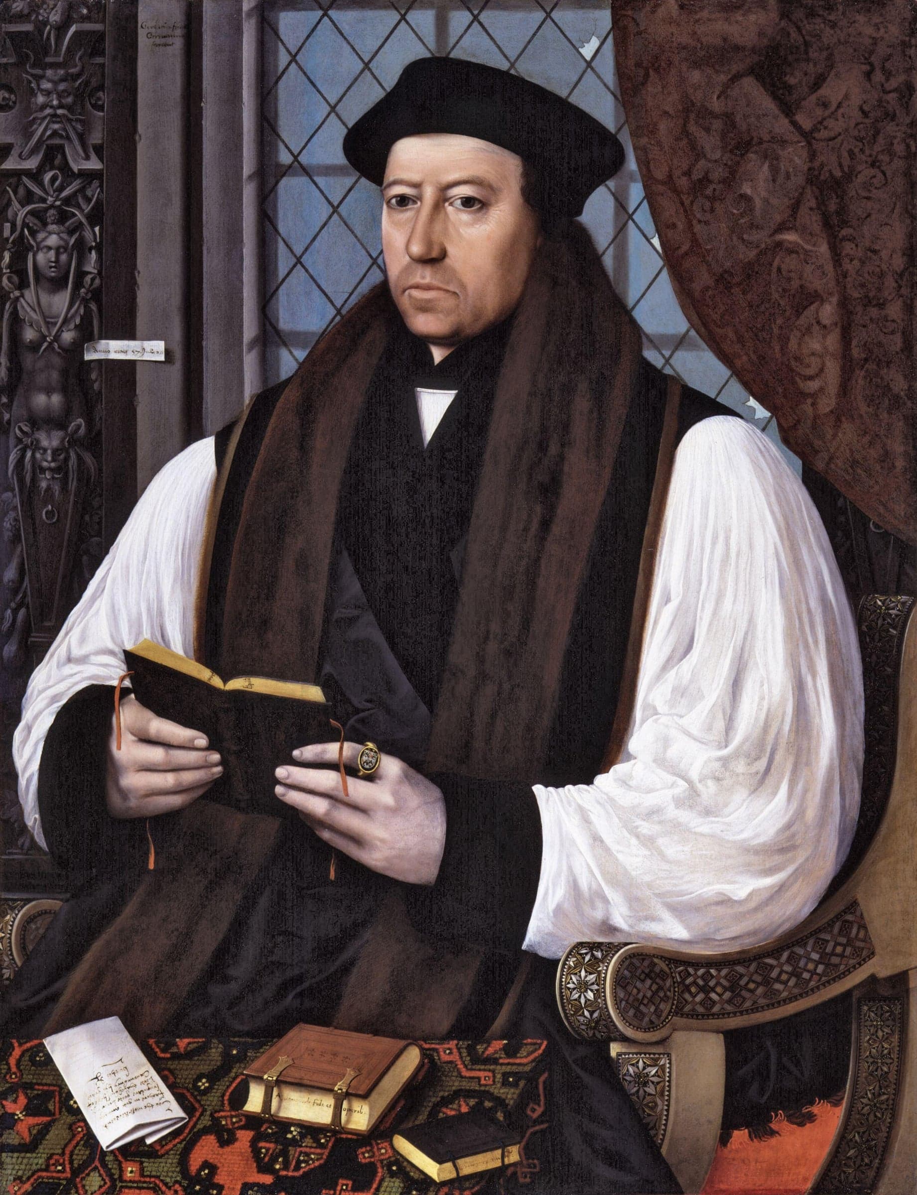 Thomas Cranmer, seated in a black cap, fur-lined gown and white sleeves, holds a small open book before a window, with letters and books on the table below.