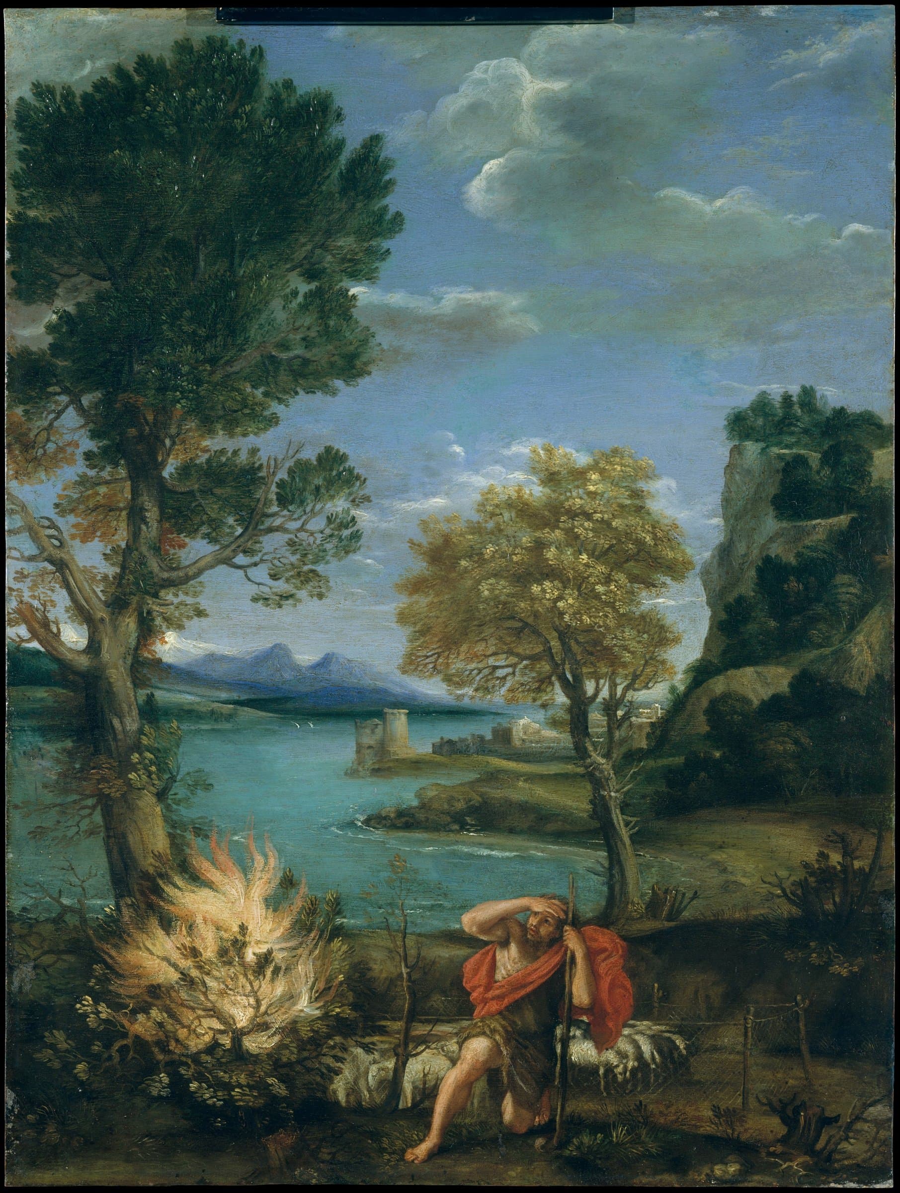 A shepherd in a red cloak kneels at the lower right with a staff, shading his eyes with his raised arm as he looks toward a low bush blazing with white and gold flame at the lower left. Sheep rest behind him, tall trees rise on both sides, and a lake with a towered town and blue mountains stretches into the distance.