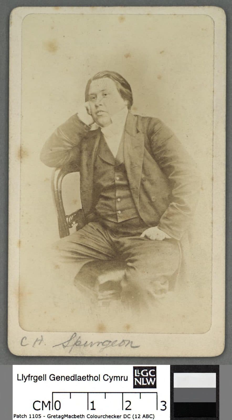 Charles Spurgeon, seated in a dark suit and waistcoat, leans his head on his right hand, on a card mount signed C. H. Spurgeon