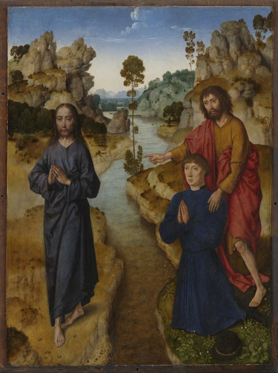 On the bank of a river between rocky hills, John the Baptist in a red cloak points across the water to Jesus, who stands barefoot in a dark robe with his hands joined, while a young man in blue kneels in prayer in front of John.