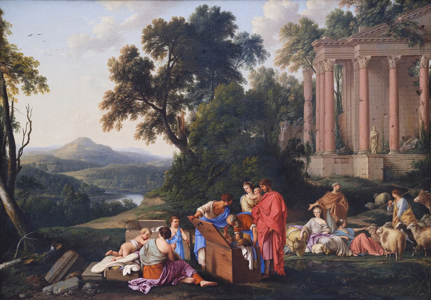 In a wide landscape of trees, a river valley and a ruined temple with pink columns, an old man in an orange robe bends over an open wooden chest while a young man holds up its lid; a man in a red cloak and a woman holding a baby stand beside them, a seated woman and two children wait by another chest, and at the right a young woman reclines against bundles and a jar beside a second woman, with sheep, goats and an ox behind them