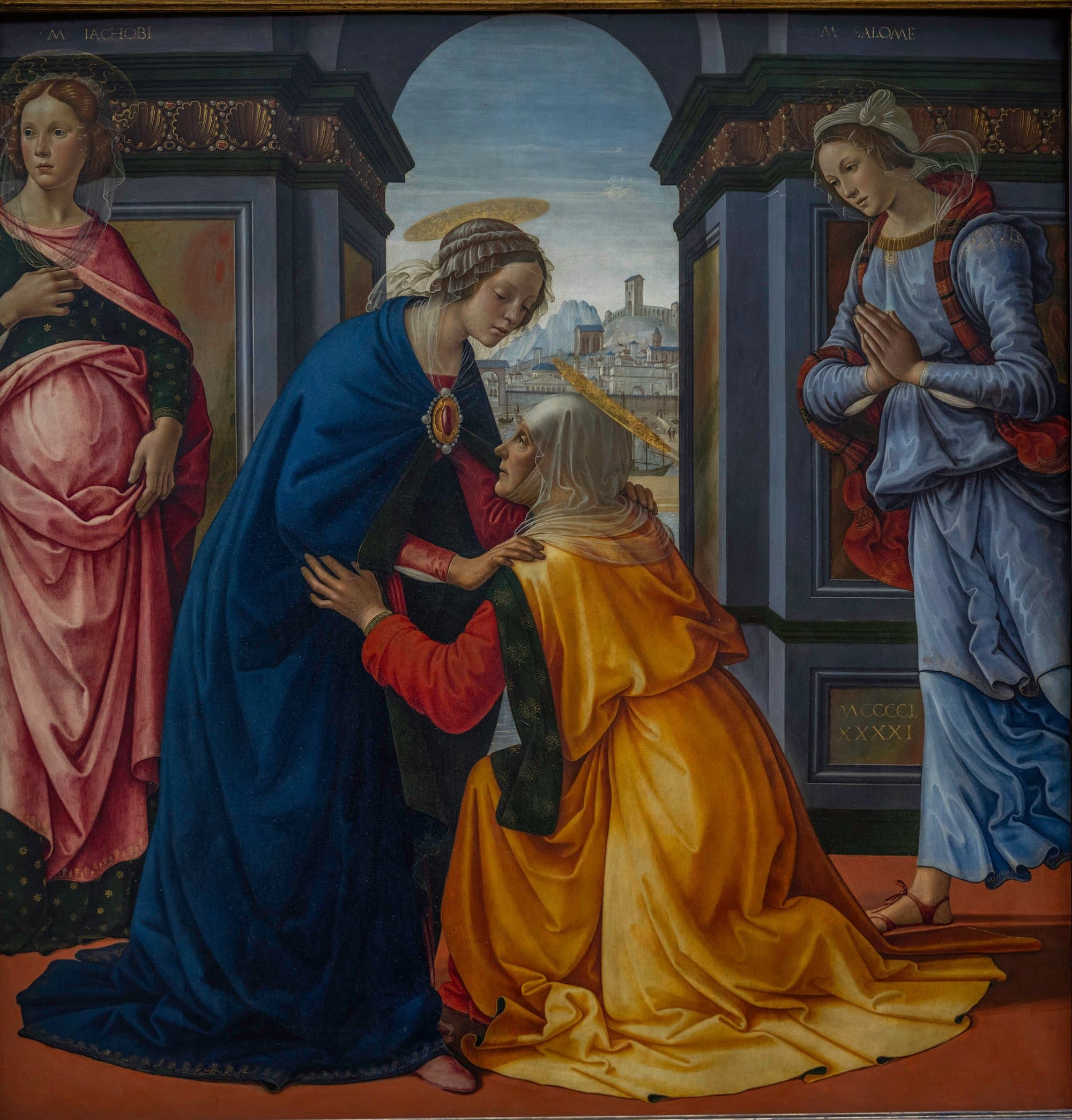 Under a stone arch that opens on a hill town and a harbour, an old woman in a golden yellow mantle kneels and holds the arms of a young woman in a dark blue mantle who bends down to embrace her, while a woman in pink and a woman in pale blue with joined hands stand at either side.