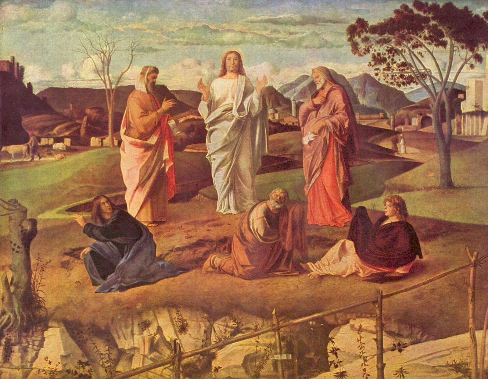 Christ in white stands on a grassy hilltop between Moses and Elijah, while Peter, James and John crouch on the ground below and a valley of farms and towns stretches behind