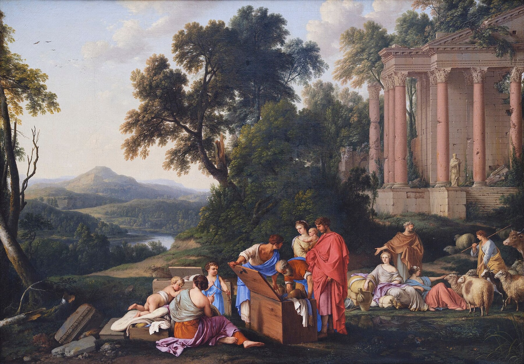 In a wide landscape of trees, a river valley and a ruined temple with pink columns, an old man in an orange robe bends over an open wooden chest while a young man holds up its lid; a man in a red cloak and a woman holding a baby stand beside them, a seated woman and two children wait by another chest, and at the right a young woman reclines against bundles and a jar beside a second woman, with sheep, goats and an ox behind them
